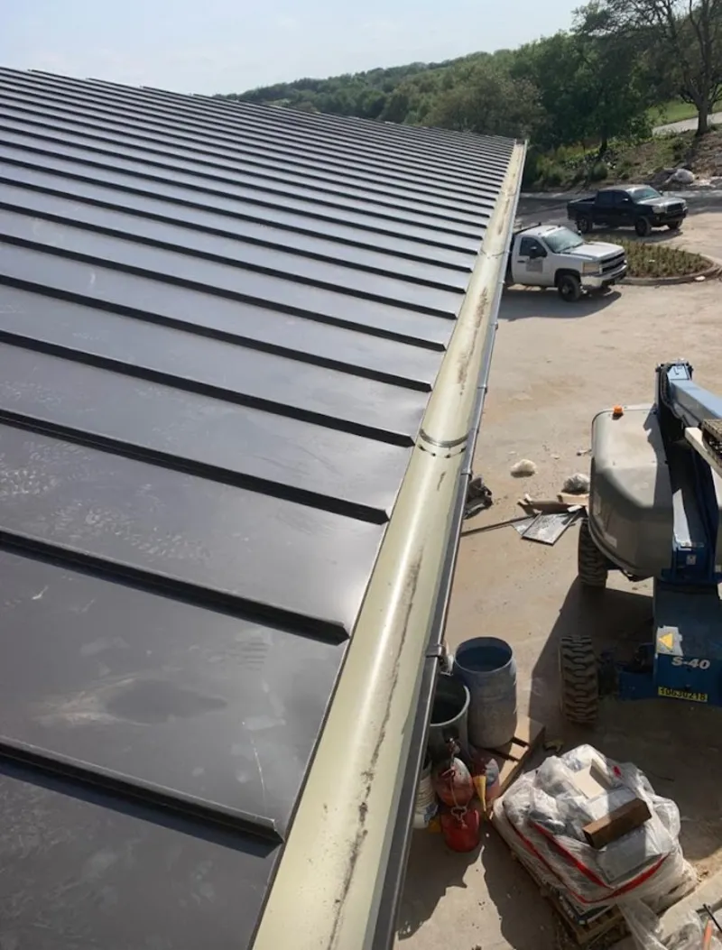 Standing seam panel and gutter detail on a metal roofing jobsite in Maysville